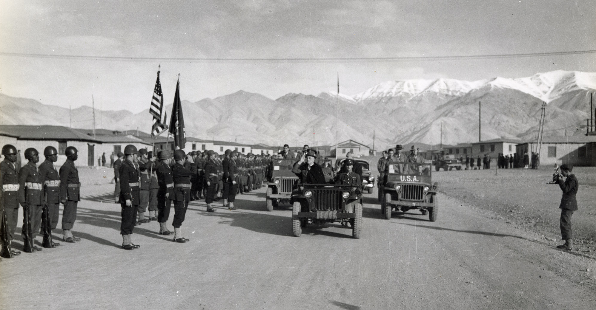 Roosevelt in a jeep passes by rows of soldiers at attention Roosevelt in a jeep passes by rows of soldiers at attention